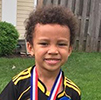 Amani posing with his soccer ball.